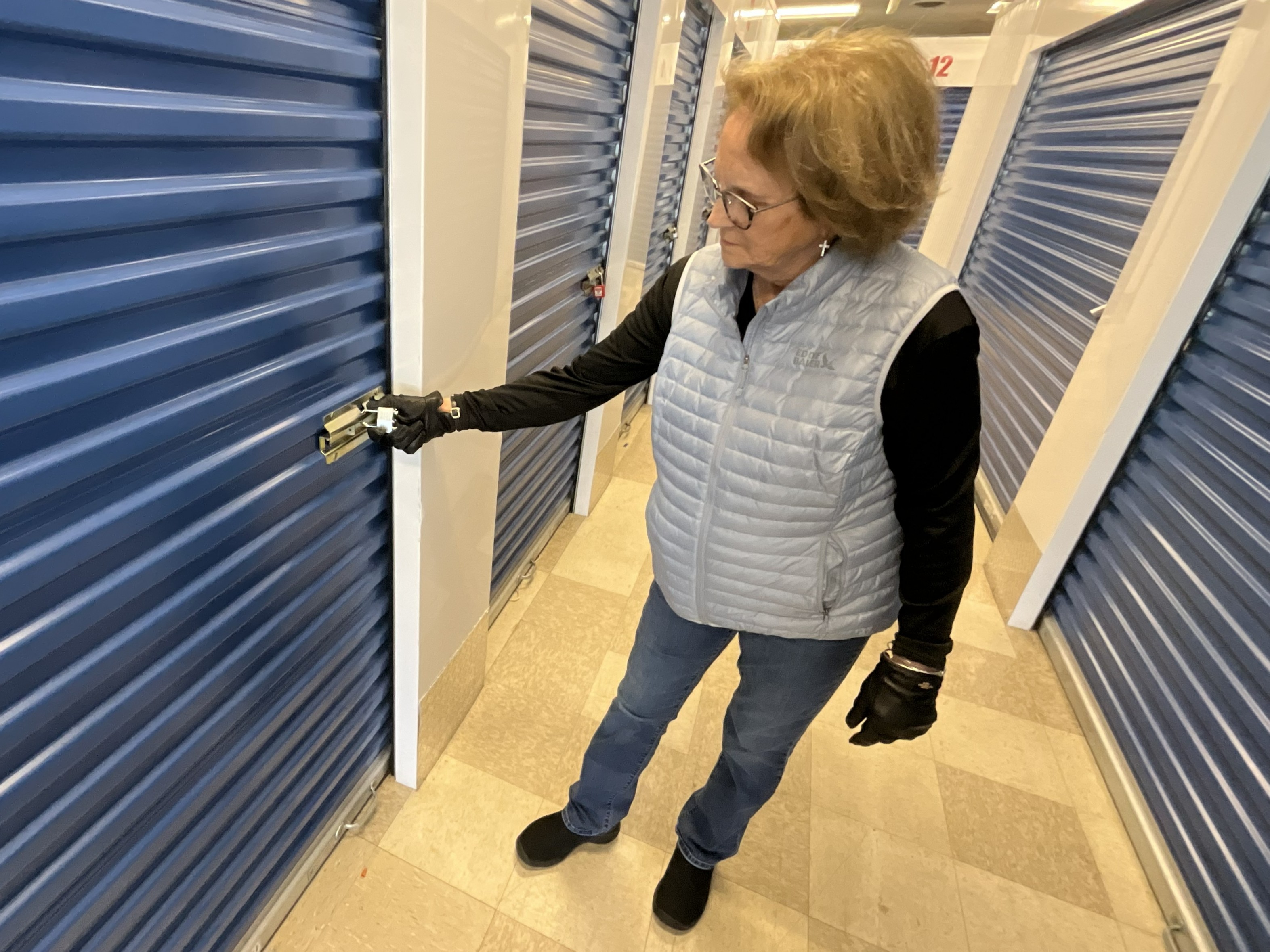 Joanne demonstrating a lock on a blue storage unit door